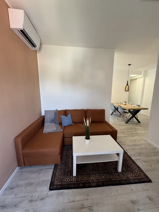Wohnbereich mit Sofa und Essplatz im Hintergrund
